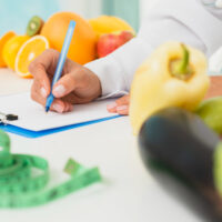 close-up-nutritionist-writing-prescription